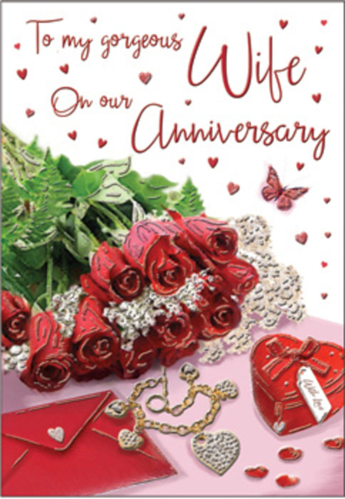This anniversary card presents a rich, emotive still life that could easily be imagined on a sideboard in a Willesden home after a special dinner. Taking centre stage is a bouquet of classic red roses, each bloom generously open and perfectly shaped, with layered petals that create a sense of depth and softness. The roses are wrapped with subtle elegance and framed by abundant greenery, the leaves adding a vibrant counterpoint that suggests freshly cut stems and careful conditioning by an experienced florist. Around the bouquet, the scene unfolds like a visual diary of cherished moments: a jewellery set nestled close by, its delicate pieces catching the light, and a vivid red box that looks ready to be opened, its surface smooth and inviting to the touch. These items evoke memories of significant anniversaries, exchanged gifts, and quiet evenings spent together after walks along Willesden Lane. Fine textures run through the design-whisper-thin lace, silky ribbon, hints of velvet and gold-that all interact with the soft, directional light, producing gentle highlights and shadows. Heart motifs appear throughout, some printed and some more sculptural, reinforcing the romantic theme without overwhelming the composition. A scripted message curves across the card, its elegant lettering conveying intimacy and tenderness even when the exact words remain indistinct. The overall mood is undeniably romantic yet grounded, reflecting the comfort of long-term devotion: rich colours, tactile materials, and thoughtfully placed keepsakes all working together to honour the depth, stability, and warmth of a love that has weathered time and grown stronger in the everyday life of Willesden.