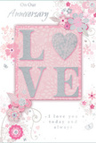 This anniversary card is a gentle celebration of enduring romance, its design echoing the soft colours and careful craftsmanship of an intimate bouquet from a local Willesden florist. At the centre, the word "LOVE" stands out in raised, glitter-accented lettering, with each character dusted in soft blush and silver shimmer. The letter "O" is cleverly replaced by a textured silver heart, making it the focal point of the design, like a single standout bloom in a mixed arrangement. Around this central word, an array of delicate blossoms unfurls in shades of blush pink, mauve, and pale ivory. The flowers are drawn with a light, almost watercolour touch, their fine lines and subtle washes of colour giving them a softly romantic feel. Slender vines and swirling tendrils curl around the blooms, evoking the natural movement of foliage arranged by hand. Small decorative flourishes-scattered petals, graceful curls, and subtle butterfly silhouettes-add a sense of motion and whimsy, bringing to mind the fresh, breezy charm of an English spring garden, even in the heart of Willesden. The palette blends pastel pinks, silvery greys, and pearly whites, creating a calm and intimate atmosphere ideal for marking a treasured milestone. Sincere phrases such as "On Our Anniversary" and "I love you today and always" appear in elegant script, their flowing lines harmonising with the curves of the vines and stems. Together, the artwork and words create a keepsake that feels both personal and timeless, ready to be paired with fresh anniversary flowers delivered to homes and hidden gems across Willesden and the surrounding streets.